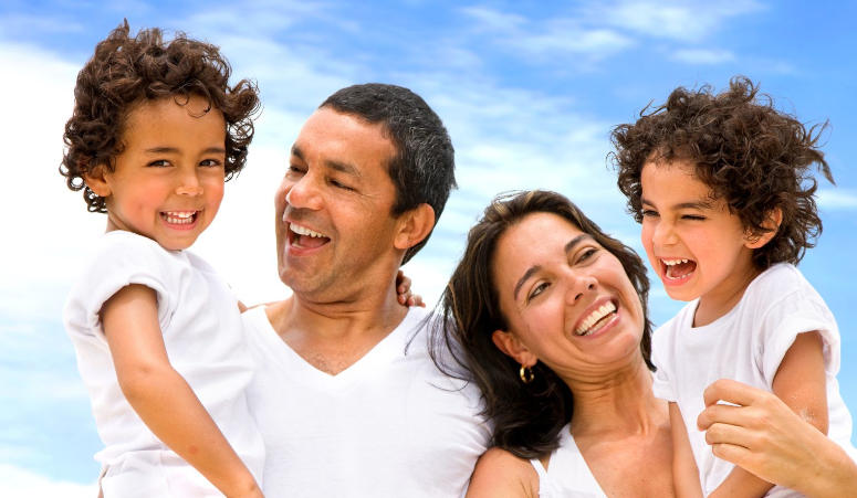 A family of 4 smiling.